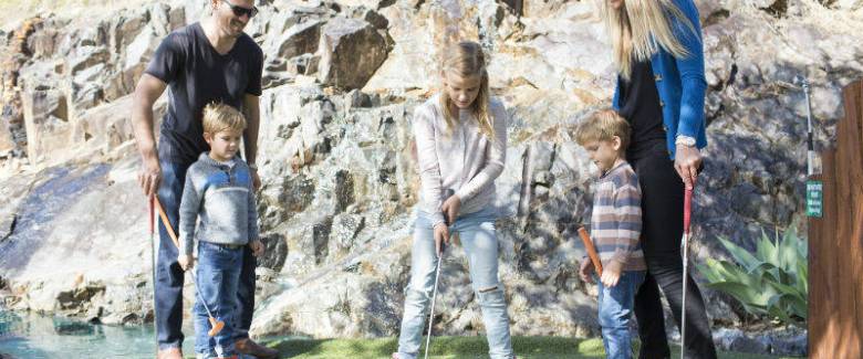 Family playing mini golf