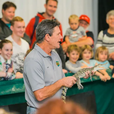 Guy holding a small reptile in a show