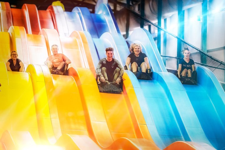 3 people playing on a giant slide