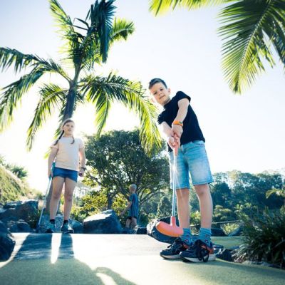 a man riding a skateboard next to a palm tree