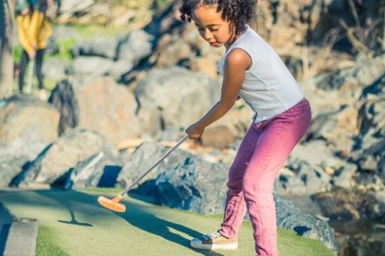 a young boy riding a skateboard up the side of the road