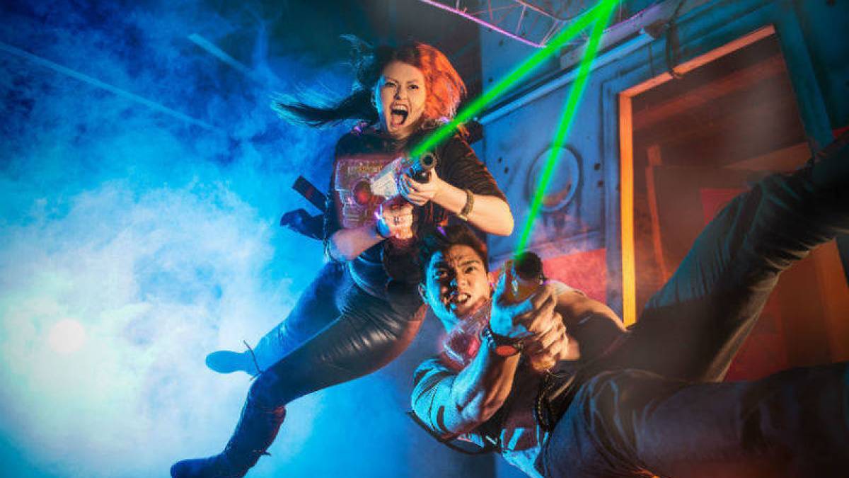 2 young people playing laser tag