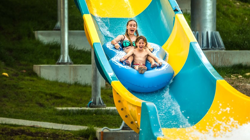 a little girl riding on a slide